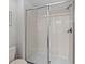 Glass enclosed shower with neutral tile and chrome hardware at 1401 Wexford Way, Davenport, FL 33896