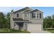 Charming two-story home showcasing board and batten siding, a two-car garage, and a well-manicured lawn at 3454 Howell Dr, Lake Wales, FL 33859