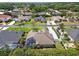Aerial view of house displaying pool, well-kept lawn, and landscaping with neighboring homes nearby at 5446 Highlands Vista Cir, Lakeland, FL 33812