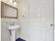 Small bathroom features a pedestal sink and framed mirror at 5446 Highlands Vista Cir, Lakeland, FL 33812