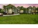 Landscaped front yard with palm trees and a circular driveway leading to a light green home at 5446 Highlands Vista Cir, Lakeland, FL 33812