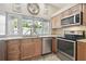 Well-lit kitchen featuring wood cabinets, granite countertops, stainless appliances and tile floors at 5446 Highlands Vista Cir, Lakeland, FL 33812