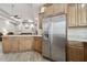 Spacious kitchen with stainless steel refrigerator and custom wood cabinets, seamlessly flowing into the inviting living area at 5446 Highlands Vista Cir, Lakeland, FL 33812