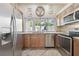 Bright kitchen with wood cabinets, granite countertops, stainless appliances and a view to the pool at 5446 Highlands Vista Cir, Lakeland, FL 33812