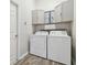 A laundry room with wood-look floors, cabinets, a washer, and a dryer at 5446 Highlands Vista Cir, Lakeland, FL 33812