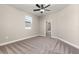 Cozy bedroom with plush carpet, a bright window, and a ceiling fan, offering a comfortable and inviting space at 7704 Somersworth Dr, Kissimmee, FL 34747