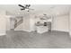 Open-concept living area featuring hardwood floors, a staircase, and a seamless transition into a modern kitchen at 7704 Somersworth Dr, Kissimmee, FL 34747