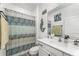 Bright bathroom boasts a shower with patterned curtain, vanity with modern fixtures, and mermaid-themed decorations at 140 Trinity Ridge Cir, Davenport, FL 33897