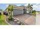 Home features a brick driveway with a landscaped yard, a two-car garage, and a well-maintained exterior at 140 Trinity Ridge Cir, Davenport, FL 33897