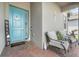 Home entryway featuring a vibrant blue door, a charming welcome sign, and cozy seating on the front porch at 140 Trinity Ridge Cir, Davenport, FL 33897