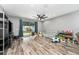 Open-concept living room featuring wood floors, a ceiling fan, and sliding glass doors to the backyard at 140 Trinity Ridge Cir, Davenport, FL 33897