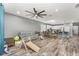 Open-concept living room includes wood floors, a ceiling fan, and connects to a modern kitchen at 140 Trinity Ridge Cir, Davenport, FL 33897