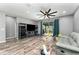 Spacious living room boasts wood floors, a large TV, and a sliding glass door that leads to the backyard at 140 Trinity Ridge Cir, Davenport, FL 33897
