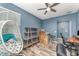 Bright office features a ceiling fan, wood-look tile floors, a desk, and a modern decorative ladder shelf at 140 Trinity Ridge Cir, Davenport, FL 33897