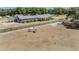 Aerial view of horse property barn with two white horses in paddock with black fencing and green trees at 25601 Hutcheson Ln, Sorrento, FL 32776