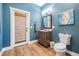 Bathroom features a blue painted wall, a wood tone vanity, and wood-look floors at 25601 Hutcheson Ln, Sorrento, FL 32776