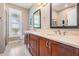 Bathroom with double sink vanity, framed mirrors and a window for natural light at 25601 Hutcheson Ln, Sorrento, FL 32776