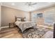 Bedroom featuring a queen bed with blue accents, a ceiling fan, and a window at 25601 Hutcheson Ln, Sorrento, FL 32776