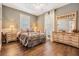 Cozy bedroom features a comfortable bed, natural light, bedside tables, and a dresser with a mirror at 25601 Hutcheson Ln, Sorrento, FL 32776