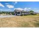 Exterior view of the property featuring a lawn, pavers and blue sky at 25601 Hutcheson Ln, Sorrento, FL 32776