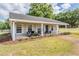 Inviting front porch with seating area on a charming home with white columns at 25601 Hutcheson Ln, Sorrento, FL 32776