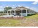 Exterior view of a horse barn featuring covered stalls, lush landscaping, and serene equestrian property at 25601 Hutcheson Ln, Sorrento, FL 32776