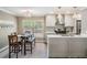 Eat-in kitchen with stainless steel appliances, herringbone backsplash and adjacent dining area at 25601 Hutcheson Ln, Sorrento, FL 32776