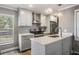 Bright kitchen with stainless steel appliances, a herringbone backsplash, and gray and white cabinetry at 25601 Hutcheson Ln, Sorrento, FL 32776