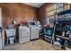 Functional laundry room with washer, dryer, sink, shelving, and window; providing ample space for cleaning and storage at 25601 Hutcheson Ln, Sorrento, FL 32776