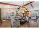 Bright, airy living room featuring exposed beams, hardwood floors, a stone fireplace, and comfortable seating at 25601 Hutcheson Ln, Sorrento, FL 32776
