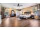 Spacious main bedroom features a decorative headboard, sitting area, natural light, and hardwood flooring at 25601 Hutcheson Ln, Sorrento, FL 32776