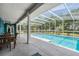 Gorgeous pool area surrounded by a screened enclosure, lush greenery, and comfortable seating, creating a private retreat at 25601 Hutcheson Ln, Sorrento, FL 32776