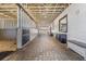 Interior stable aisle with brick floors, white walls, and wood accents, creating a clean and functional space at 25601 Hutcheson Ln, Sorrento, FL 32776