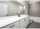 Bathroom features a quartz countertop, modern fixtures, and gray tiled shower and bath at 3319 Chinotto Dr, Lake Alfred, FL 33850