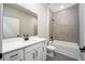 Bathroom features a quartz countertop, modern fixtures, and gray tiled shower and bath at 3319 Chinotto Dr, Lake Alfred, FL 33850