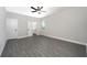 Spacious bedroom with gray flooring, ceiling fan, and an open door to the bathroom at 3319 Chinotto Dr, Lake Alfred, FL 33850