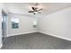 Bright bedroom with gray floors, a ceiling fan, and sliding glass doors at 3319 Chinotto Dr, Lake Alfred, FL 33850