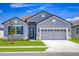 Charming single-Gathering home with a well-manicured lawn and two-car garage on a sunny day at 3319 Chinotto Dr, Lake Alfred, FL 33850
