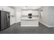 Modern kitchen with stainless steel refrigerator, white cabinets, and large center island at 3319 Chinotto Dr, Lake Alfred, FL 33850