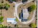 Aerial view of the property showcasing the home's layout, surrounding landscaping, outbuildings, and circular driveway at 4145 Willis Rd, Mulberry, FL 33860