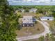Overhead shot of a home and outbuilding with an extended circular drive, lush trees and view of a distant community at 4145 Willis Rd, Mulberry, FL 33860