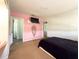 Bedroom with pink accent wall, plush carpet and wall-mounted TV at 4145 Willis Rd, Mulberry, FL 33860