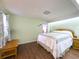 Comfortable bedroom features wood floors, natural light, and soothing green walls, creating a peaceful space at 4145 Willis Rd, Mulberry, FL 33860