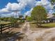 Long driveway leading to a white house under a blue sky with puffy white clouds at 4145 Willis Rd, Mulberry, FL 33860