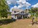 Beautiful farmhouse with front porch, American flag, mature landscaping, and brick sidewalk at 4145 Willis Rd, Mulberry, FL 33860