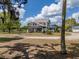 Charming two-story home with front porch, blue balcony and expansive lawn on a sunny day at 4145 Willis Rd, Mulberry, FL 33860