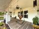 Cozy front porch featuring a swing, hanging plants, and a view of the well-manicured lawn at 4145 Willis Rd, Mulberry, FL 33860