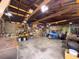 Exposed beams, concrete floors, and ample shelving for storage creates a functional workspace within this versatile garage at 4145 Willis Rd, Mulberry, FL 33860
