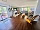 Cozy living room boasts hardwood floors, fireplace, and sliding glass door to screen porch at 4145 Willis Rd, Mulberry, FL 33860