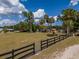 Lush acreage featuring a well-maintained lawn, mature trees, and a classic black fence at 4145 Willis Rd, Mulberry, FL 33860